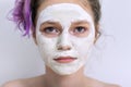 Young beautiful teen girl with white cosmetic natural healing mask on face