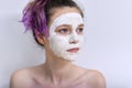 Young beautiful teen girl with white cosmetic natural healing mask on face