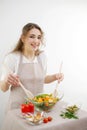 young beautiful teenage girl stirs diligently salad she leaned over bowl little smiling green lettuce leaves tablecloth Royalty Free Stock Photo