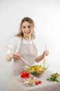 young beautiful teenage girl stirs diligently salad she leaned over bowl little smiling green lettuce leaves tablecloth Royalty Free Stock Photo