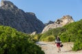 Young, beautiful, teenage woman with backpack hiking in mountains