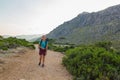 Young, beautiful, teenage woman with backpack hiking in mountains