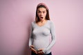 Young beautiful teenager girl pregnant expecting baby over isolated pink background afraid and shocked with surprise and amazed Royalty Free Stock Photo