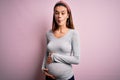 Young beautiful teenager girl pregnant expecting baby over isolated pink background making fish face with lips, crazy and comical Royalty Free Stock Photo