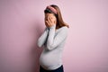 Young beautiful teenager girl pregnant expecting baby over isolated pink background rubbing eyes for fatigue and headache, sleepy