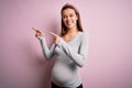 Young beautiful teenager girl pregnant expecting baby over isolated pink background smiling and looking at the camera pointing Royalty Free Stock Photo