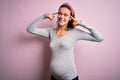 Young beautiful teenager girl pregnant expecting baby over isolated pink background smiling pointing to head with both hands Royalty Free Stock Photo