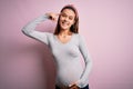 Young beautiful teenager girl pregnant expecting baby over isolated pink background Smiling pointing to head with one finger, Royalty Free Stock Photo