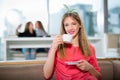 Young beautiful teenager girl sitting in cafe with a white cup, Royalty Free Stock Photo