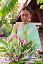 Young Beautiful Thai Asian woman dressing in vintage retro Traditional Thai costume arranging flower vase. Thailand Cultural and