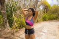 Young beautiful tired and breathless runner Asian woman exhausted and sweaty after hard running workout at trail road park in