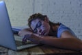 Young beautiful and tired student girl sleeping taking a nap lying on home laptop computer desk exhausted and wasted spending nigh Royalty Free Stock Photo