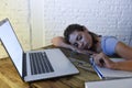 Young beautiful and tired student girl sleeping taking a nap lying on home laptop computer desk exhausted and wasted spending nigh Royalty Free Stock Photo