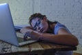 Young beautiful and tired student girl sleeping taking a nap lying on home laptop computer desk exhausted and wasted spending nigh Royalty Free Stock Photo