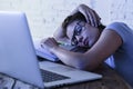 Young beautiful and tired student girl sleeping taking a nap lying on home laptop computer desk exhausted and wasted spending nigh Royalty Free Stock Photo