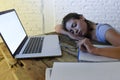 Young beautiful and tired student girl sleeping taking a nap lying on home laptop computer desk exhausted and wasted spending nigh Royalty Free Stock Photo