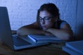 Young beautiful and tired student girl sleeping taking a nap lying on home laptop computer desk exhausted and wasted spending nigh Royalty Free Stock Photo