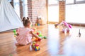 Young beautiful toddler sitting on the floor playing with small cars toys at kindergaten Royalty Free Stock Photo