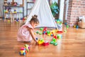 Young beautiful toddler sitting on the floor playing with small cars toys at kindergaten Royalty Free Stock Photo