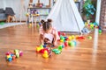 Young beautiful toddler sitting on the floor playing with small cars toys at kindergaten Royalty Free Stock Photo