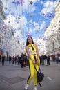 Young beautiful tourist posing against the background of garlands on Nikolskaya street in the center of Moscow