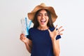 Young beautiful tourist woman holding boarding pass ticket over isolated white background very happy and excited, winner Royalty Free Stock Photo