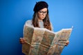 Young beautiful tourist woman on vacation wearing glasses and beret holding city map with a confident expression on smart face Royalty Free Stock Photo