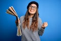 Young beautiful tourist woman on vacation wearing glasses and beret holding city map screaming proud and celebrating victory and Royalty Free Stock Photo