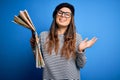 Young beautiful tourist woman on vacation wearing glasses and beret holding city map very happy and excited, winner expression Royalty Free Stock Photo