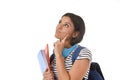 Young beautiful and trendy latin student girl holding notepad folder and book carrying backpack thinking happy Royalty Free Stock Photo