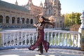 Young and beautiful typical Spanish woman dancing flamenco with urban and modern clothes, wearing her hair loose and long. Concept Royalty Free Stock Photo