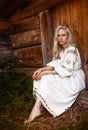 Young beautiful Ukrainian woman in national embroidered shirt sitting near old historic house Royalty Free Stock Photo