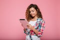 Young caucasian brunette lady using tablet computer isolated over pink Royalty Free Stock Photo