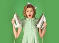 Young beautiful vintage housewife ironing on green background. Woman with iron. Royalty Free Stock Photo