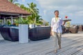 Young beautiful waitress walking with the cocktail on the tray at the tropical`s island bar Royalty Free Stock Photo