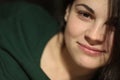 Young beautiful white dark-haired girl in a green T-shirt lies smiling on the bed Royalty Free Stock Photo