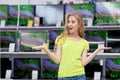 Young woman looks at TVs in shop Royalty Free Stock Photo