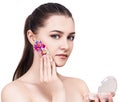 Young beautiful woman applying flowers cosmetic on face. Royalty Free Stock Photo