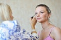 Young beautiful woman applying make-up by make-up artist Royalty Free Stock Photo