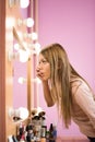 Young beautiful woman applying mascara on eyelashes near mirror indoors. Royalty Free Stock Photo