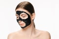 Young beautiful woman applying a mask for the face of the therapeutic black mud. Spa treatment Royalty Free Stock Photo