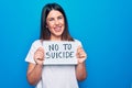 Young beautiful woman asking for psychical problem holding paper with not to suicide message looking positive and happy standing