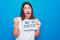 Young beautiful woman asking for psychical problem holding paper with not to suicide message screaming proud, celebrating victory Royalty Free Stock Photo