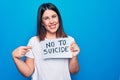 Young beautiful woman asking for psychical problem holding paper with not to suicide message smiling happy pointing with hand and Royalty Free Stock Photo