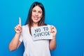Young beautiful woman asking for psychical problem holding paper with not to suicide message smiling with an idea or question