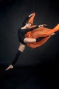 young beautiful woman athlete gymnast in motion on black background