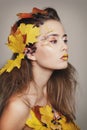 Young beautiful woman with autumn make up and leaves on head. Be Royalty Free Stock Photo