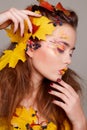 Young beautiful woman with autumn make up and leaves on head. Be Royalty Free Stock Photo