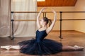 Young and beautiful woman in ballet dress and pointe dance. The ballerina warms up in the classroom. The ballerina`s