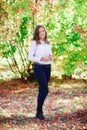 Young beautiful woman. Beauty smiling teenager girl in autumn park Royalty Free Stock Photo